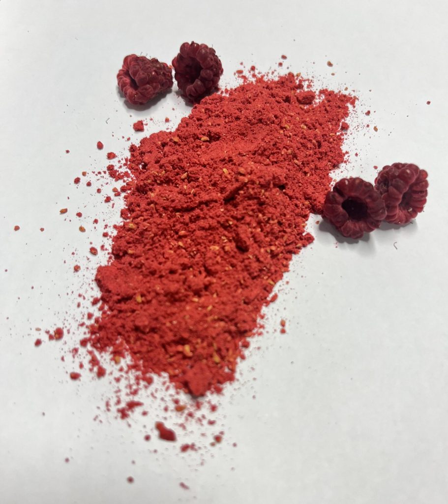 Dried raspberries and a powdered version displayed on a white background.